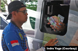 Warga mendapat penjelasan mengenai Cinta, Bangga dan Paham mengenai uang Rupiah dari petugas yang melayani pertukaran uang pecahan kecil di GBK, Jakarta Pusat pada Minggu (9/4). (Foto: VOA/Indra Yoga)