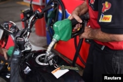 Seorang pekerja memompa bahan bakar di pom bensin perusahaan minyak milik negara PDVSA, di Caracas, Venezuela, 2 Desember 2022. (Foto: REUTERS/Gaby Oraa)