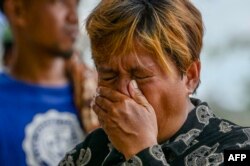 Ibu seorang siswa menangis saat wawancara dengan AFP usai bentrokan antara warga dan aparat keamanan di sebuah sekolah menengah pertama di Tanjung Kertang di Pulau Rempang, 18 September 2023. (Bay ISMOYO / AFP)