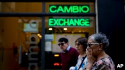 Pejalan kaki melewati tempat penukaran uang di Buenos Aires, Argentina, 10 Oktober 2023. (Foto: AP)